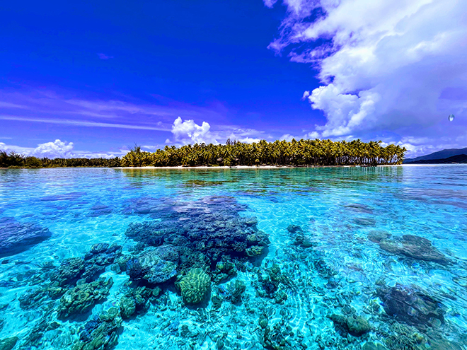 Blue water, sky, and corals off the coast of Tahiti, French Polynesia.