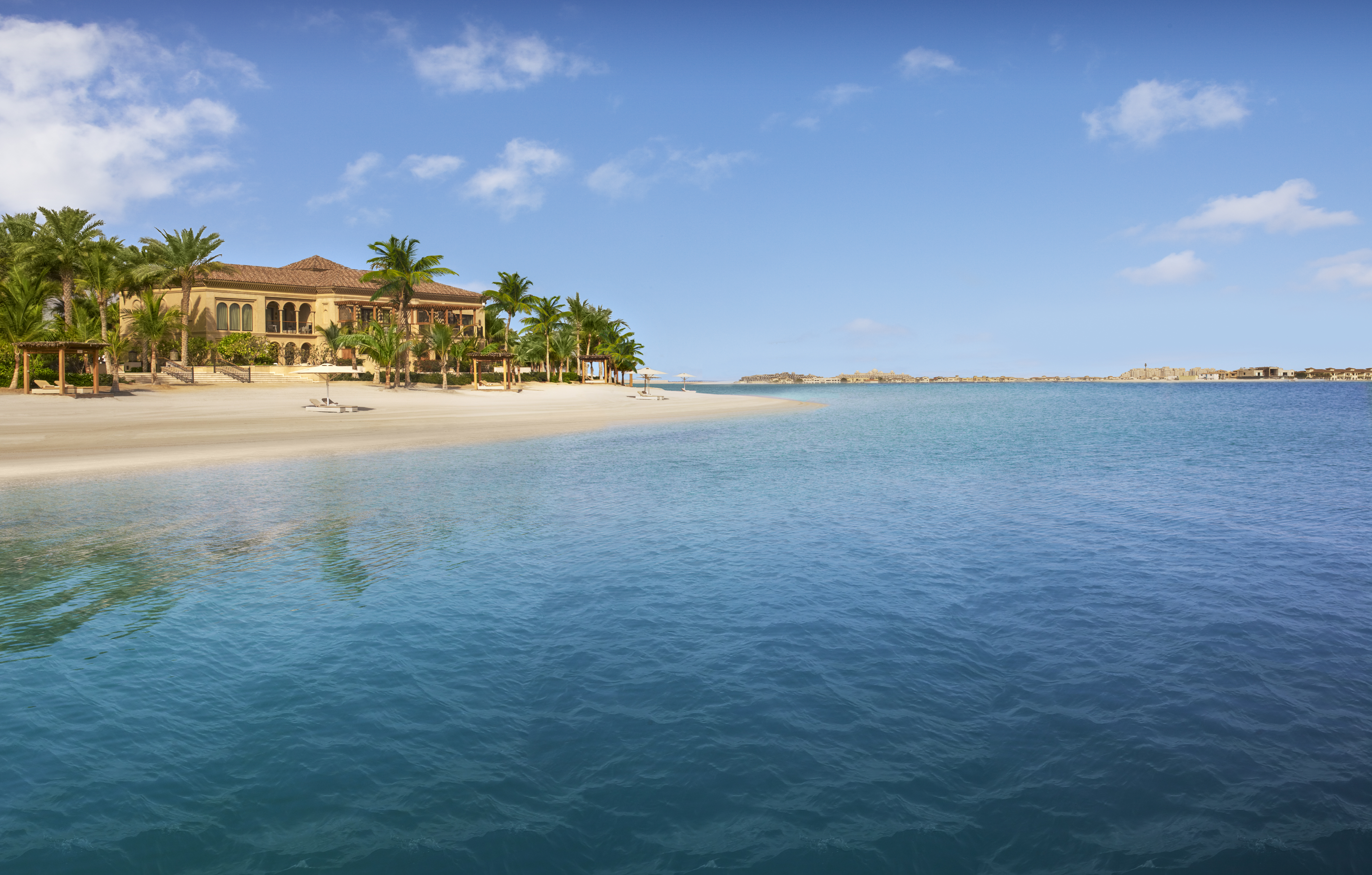 A perfectly manicured beach rolls away from the shady palm trees of One & Only The Palm, Dubai