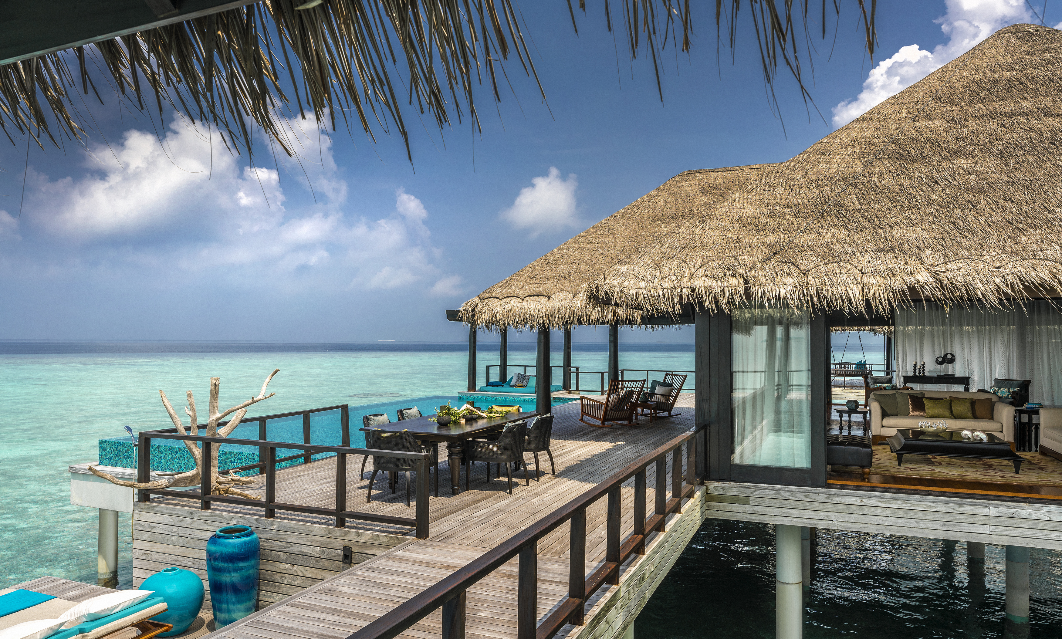 The deck and exterior of a two bedroom overwater villa has lovely dining areas overlooking the sea at Anantara Kihavah Villas, the Maldives