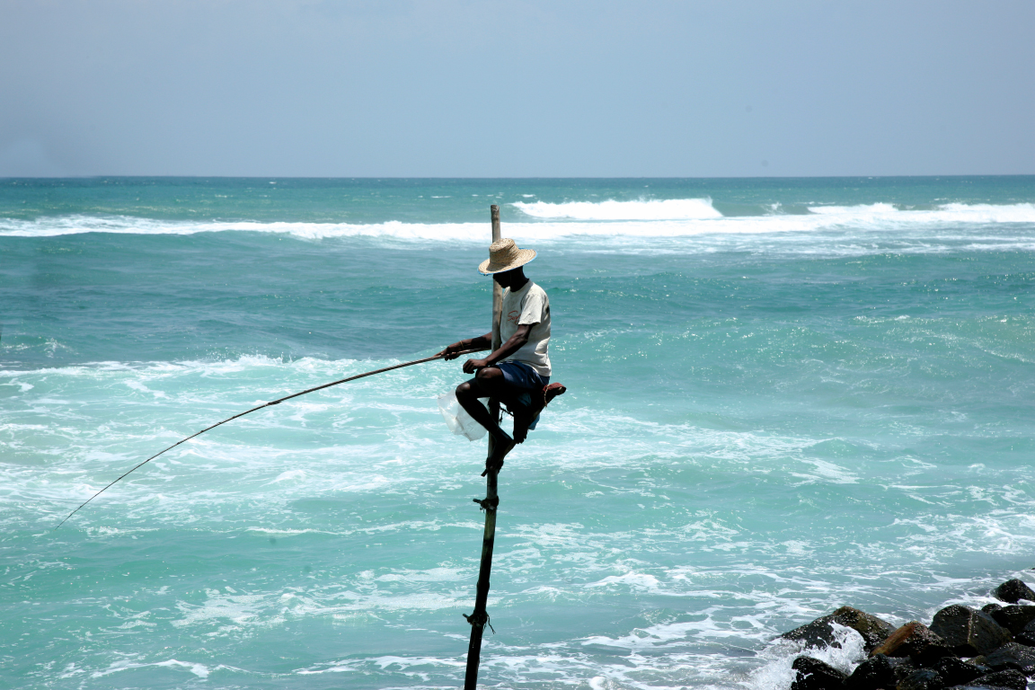 Fisherman on stilts in the sea in Sri Lanka