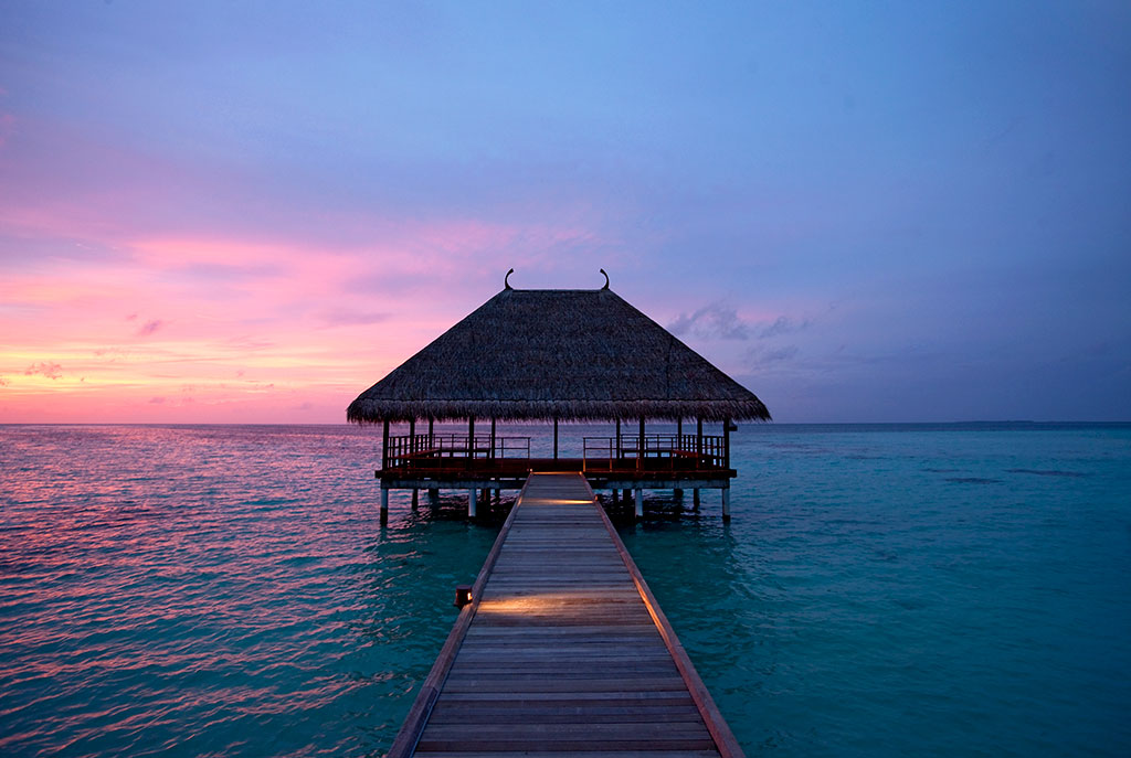 Honeymoon jetty at sunset with purple sky over the water at constance moofushi
