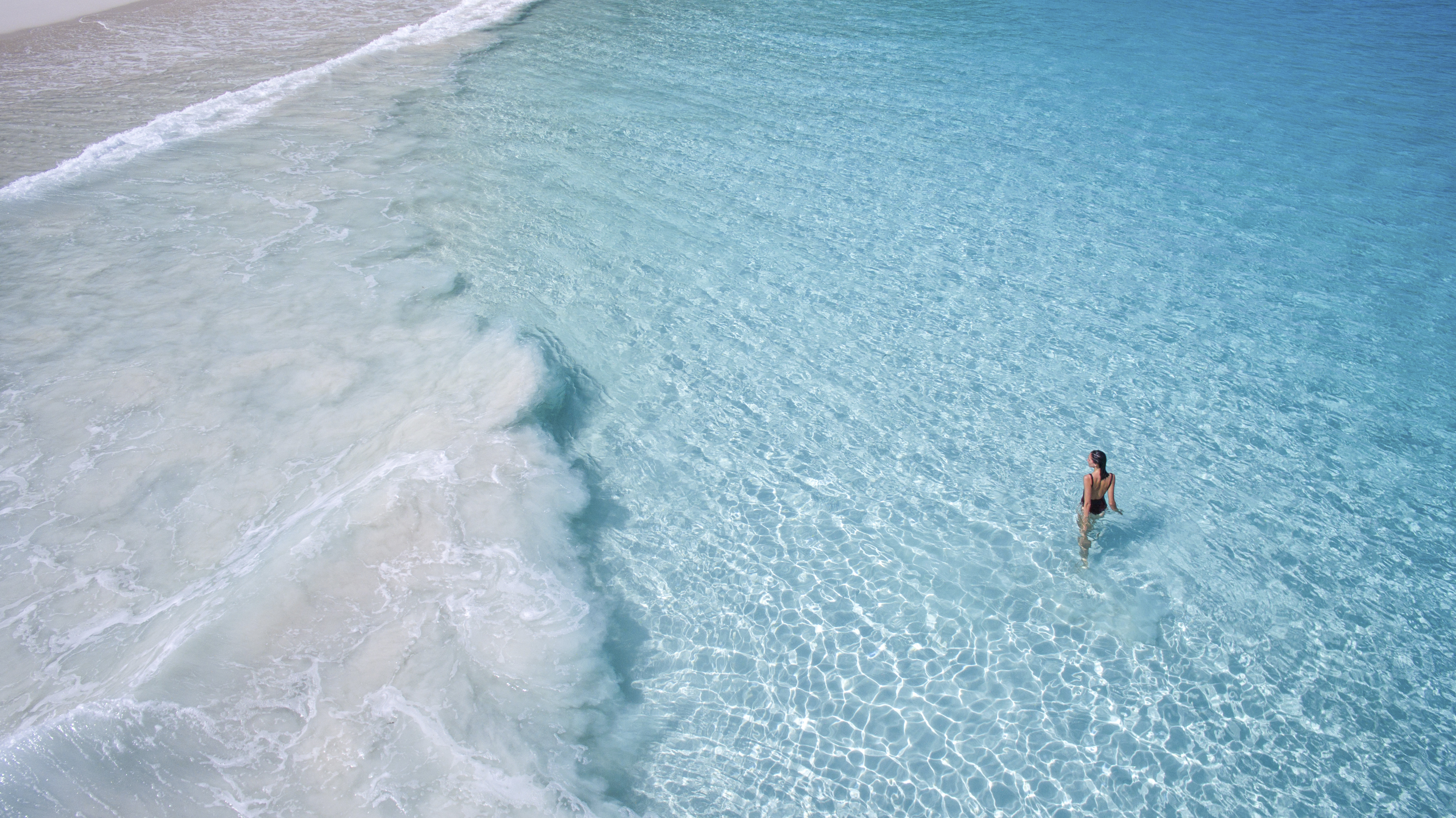 Lady in clear ocean water in the Seychelles